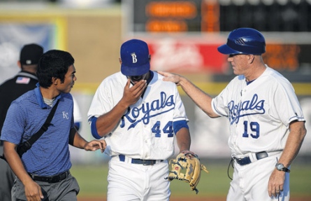 2014 Burlington Royals shortstop Marten Gasparini, center, is tended to by trainer Saburo Hagihara and manager Tommy Shields after he was struck in the face by a thrown ball which nearly broke his nose.